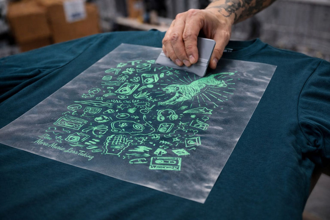 Turquoise graphic being heat pressed onto a midnight t-shirt