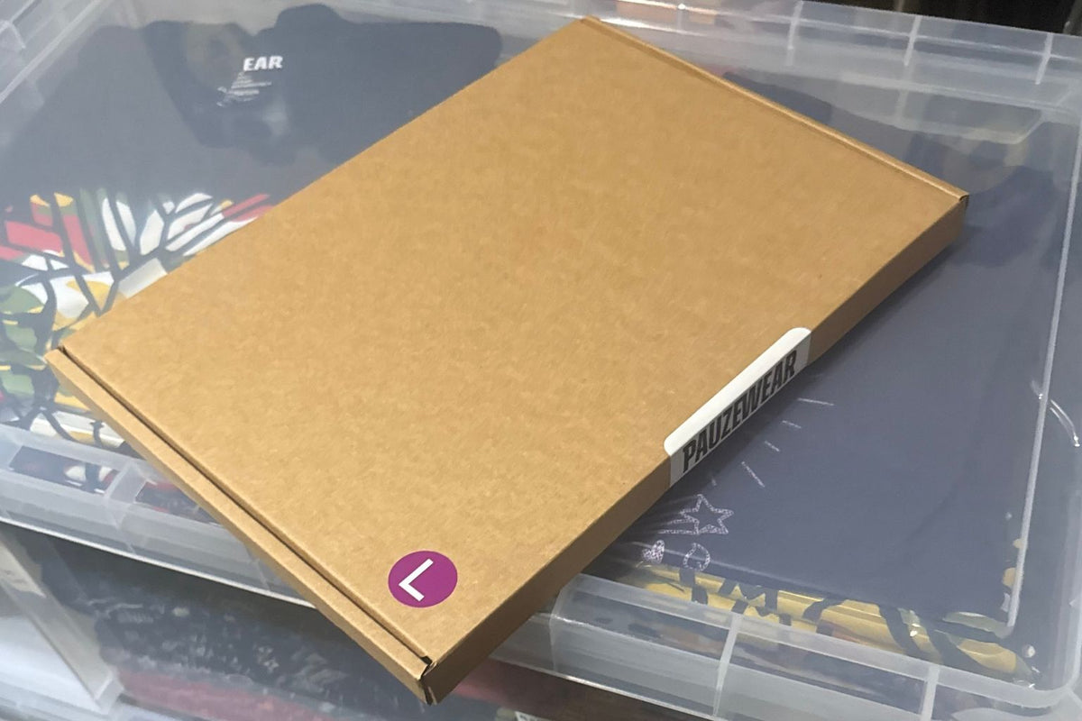 picture of a packaging box with a size sticker on and a pauzewear branded sticker