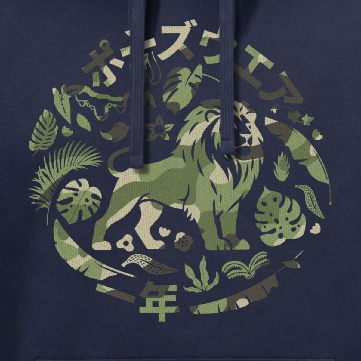 Close-up of a navy blue hoodie featuring a circular graphic print with a green and beige lion surrounded by tropical leaves and Japanese characters.