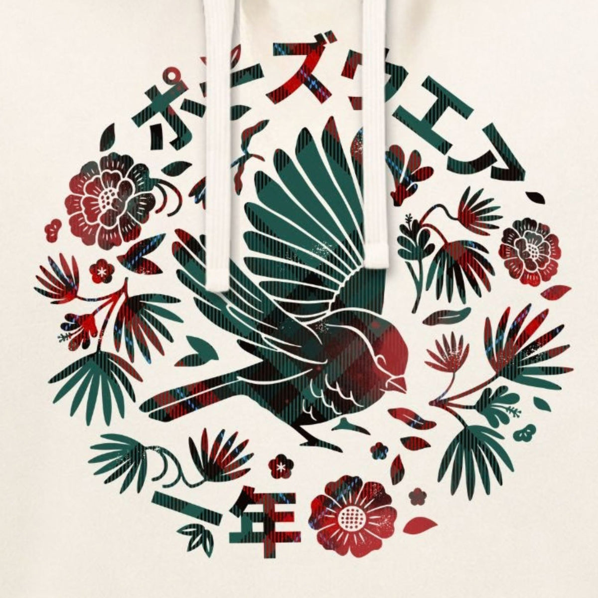 A close-up of a hoodie featuring a circular graphic print with a bird, flowers, leaves, and Japanese characters on an off-white fabric.