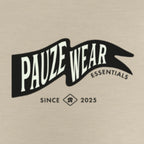 A beige fabric surface with a black and white graphic print reading 'PAUZE WEAR ESSENTIALS' and 'SINCE 2025' below it.